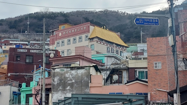 부산 서구 아미동 언덕길에 우뚝 서 있는 티베트 불교 사원. 건물 상층부의 적색 외벽과 황금색 돌출형 지붕이 눈길을 붙잡는다. 김희돈 기자